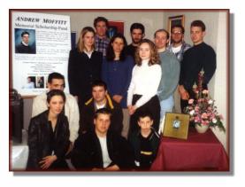 Mike and Andy's Friends posing in front of the Scholarship Fund poster